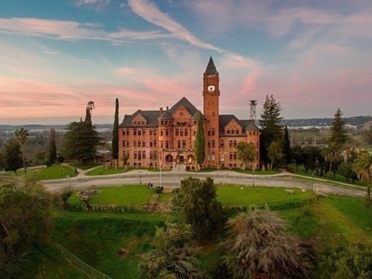 a clock tower on top of a lush green hillside