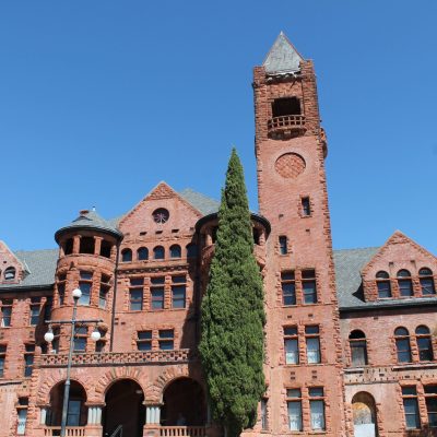 a large clock tower in front of a brick building