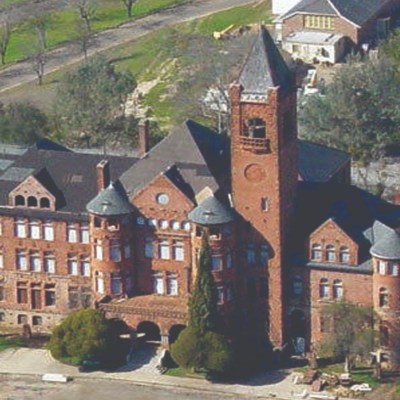a large brick building with a mountain in the background