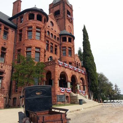 a close up of a horse drawn carriage in front of a brick building