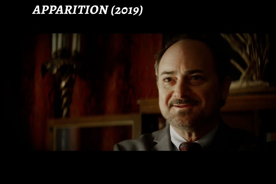 Kevin Pollak wearing a suit and tie