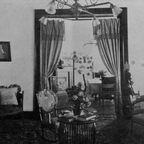 a vintage photo of a living room filled with furniture and a lamp