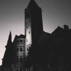 a castle with a clock tower lit up at night